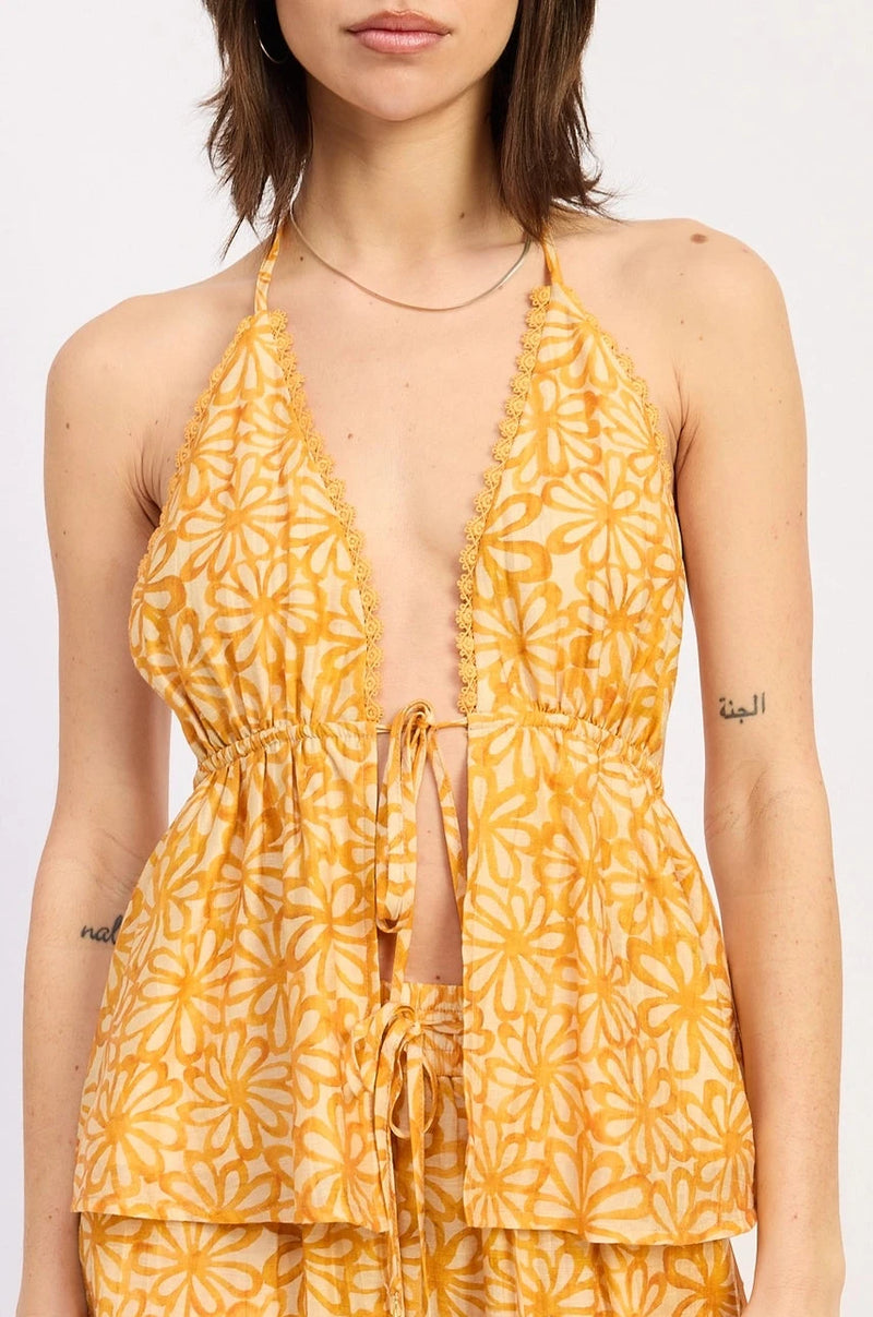 Woman wearing a yellow floral halter on a white background
