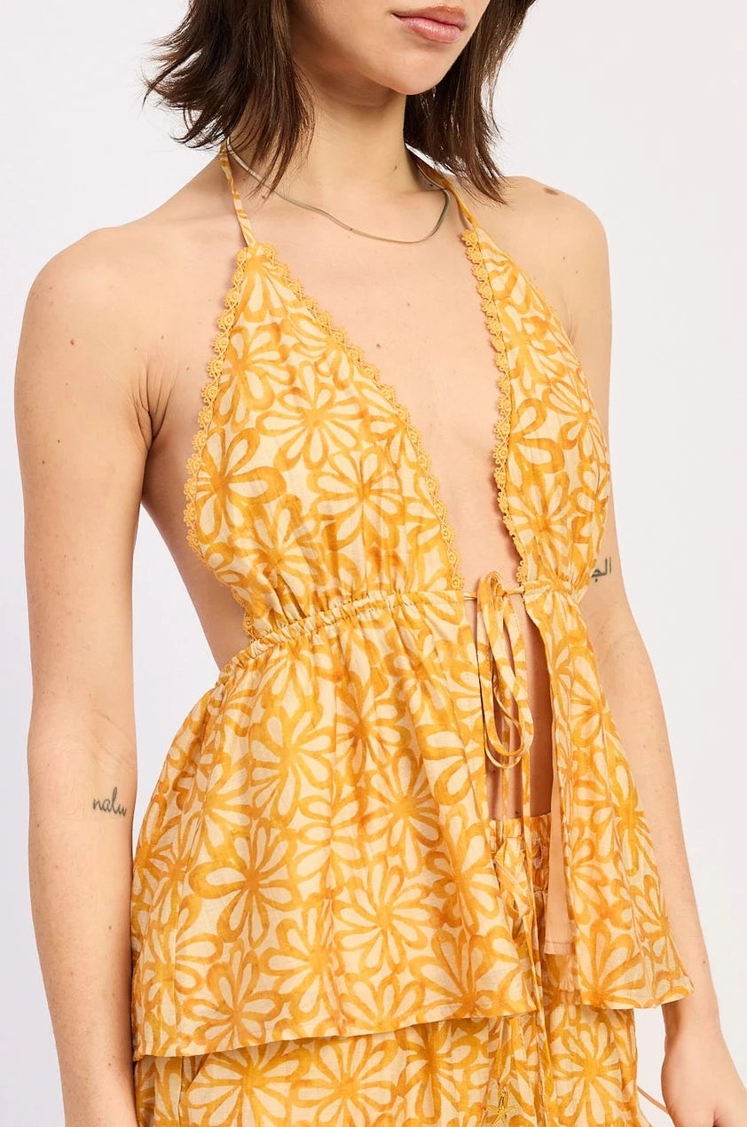 Woman wearing a yellow floral halter on a white background