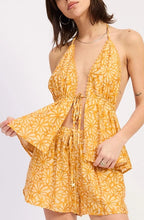 Woman wearing a yellow floral halter on a white background