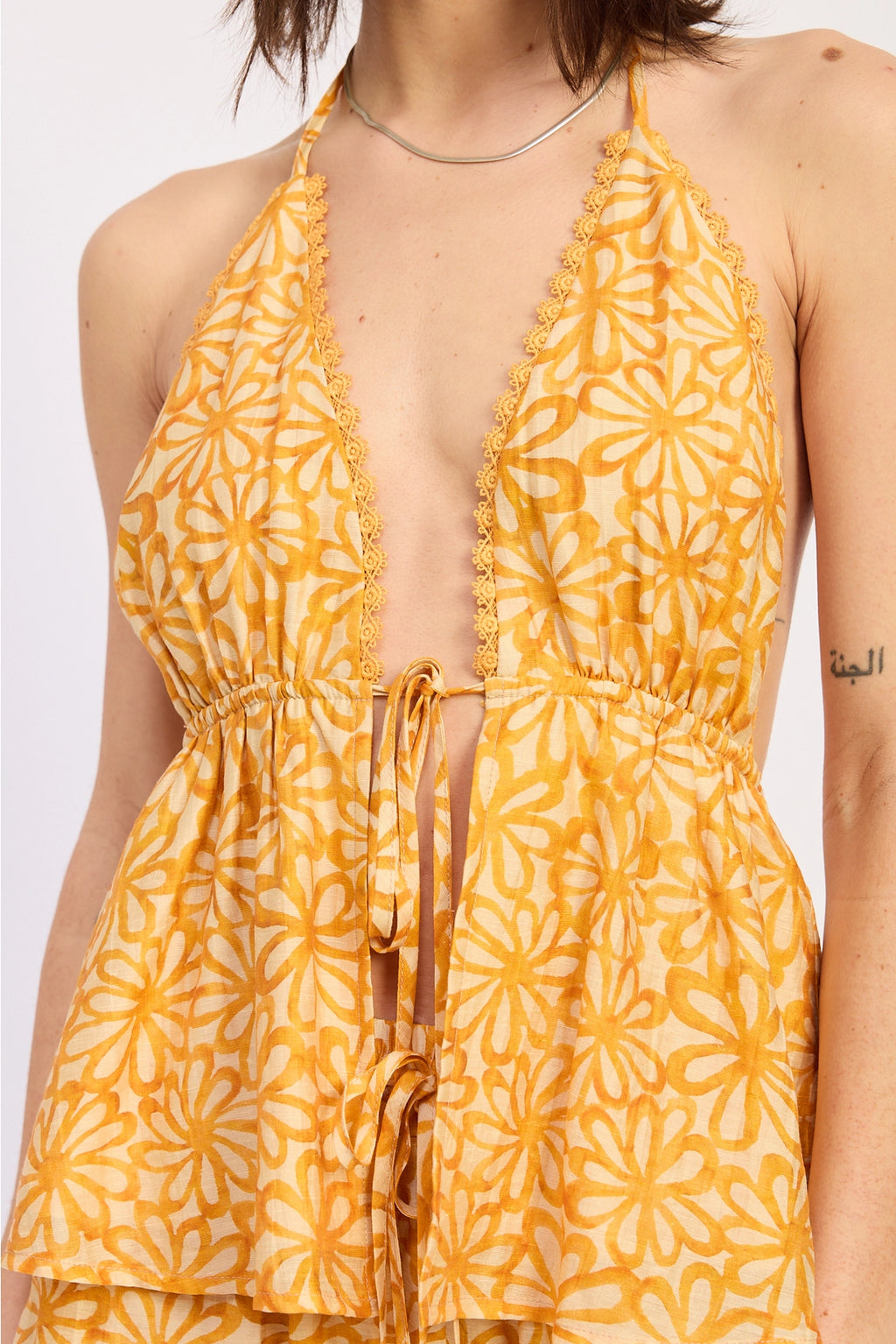 Yellow floral patterned halter on a plain background