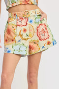Person wearing a colorful floral skirt on a plain background
