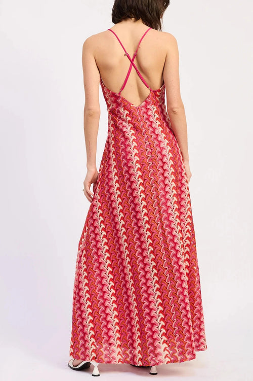 Woman wearing a red patterned dress with a white background