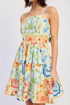 Woman wearing a colorful floral dress on a plain background