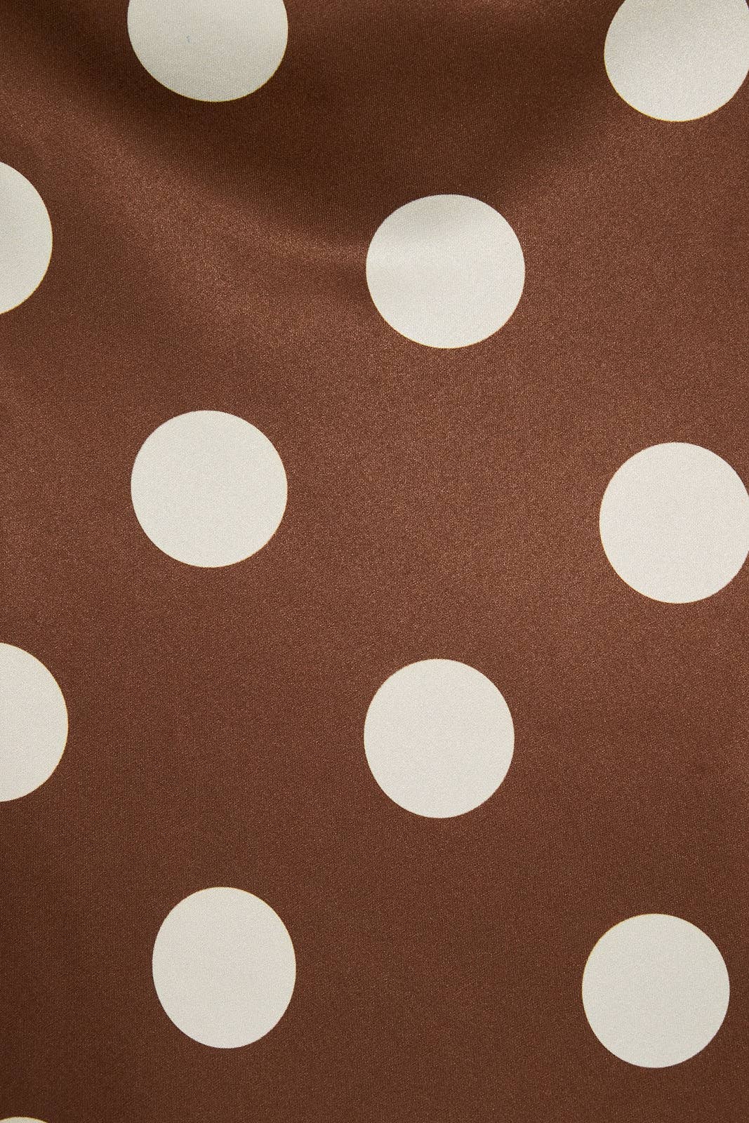 Brown fabric with a large white polka dot pattern, shown in a close-up texture view.