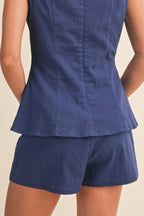 Navy blue peplum top and shorts set on a beige background
