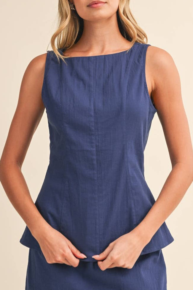 Woman wearing a blue top against a beige background