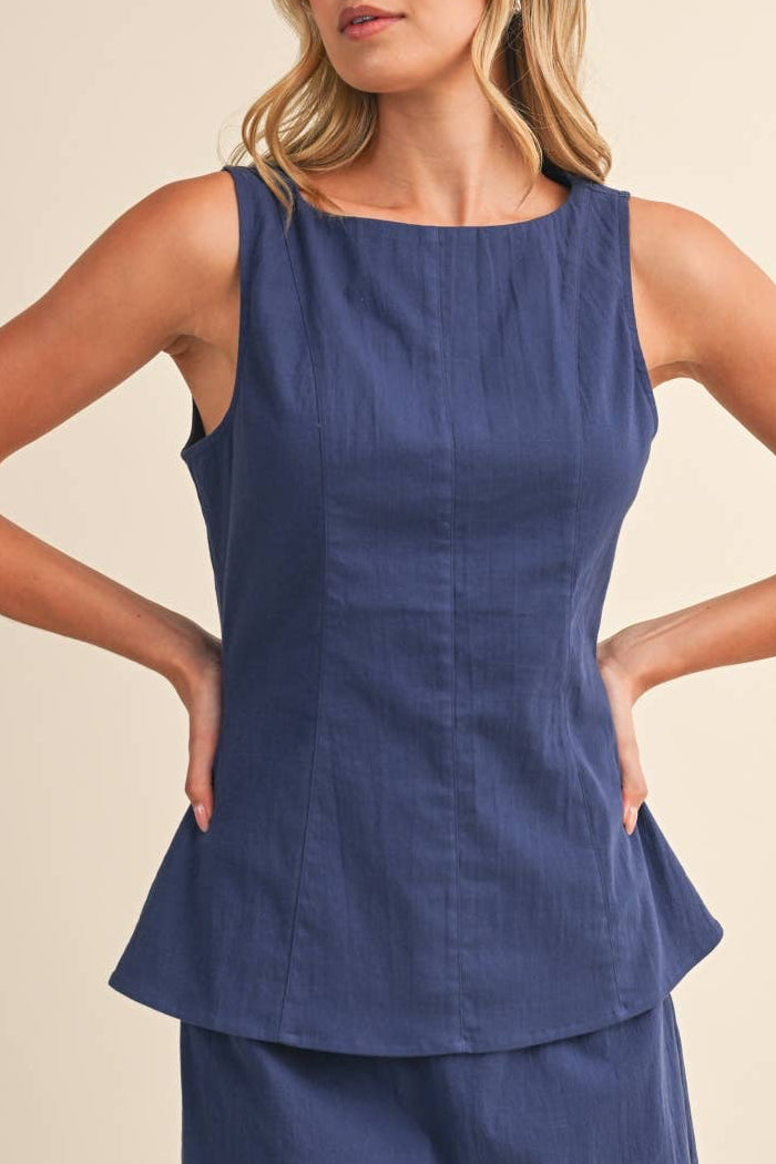 Woman wearing a blue top against a beige background