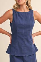 Woman wearing a blue top against a beige background