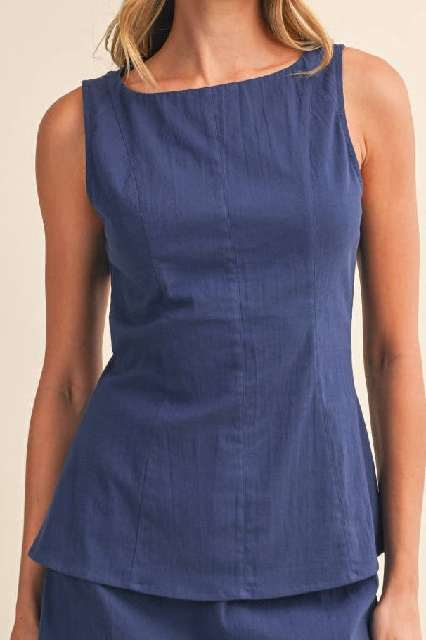 Woman wearing a blue sleeveless top and skirt set on a beige background