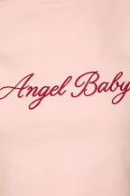A close-up of a light pink sweatshirt featuring the words 'Angel Baby' embroidered in red cursive script across the chest.