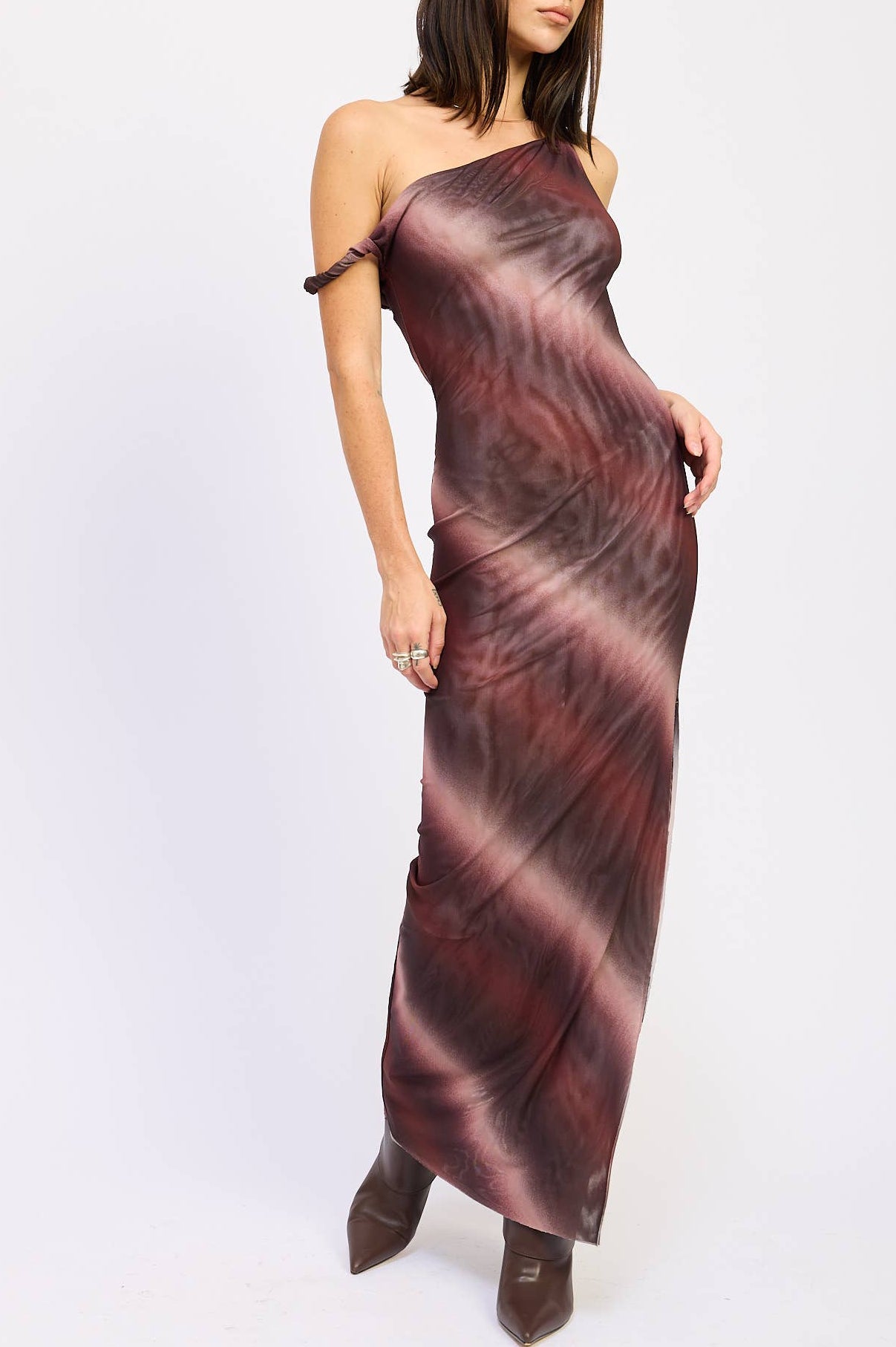 Woman wearing a one-shoulder dress with a maroon and brown gradient on a white background