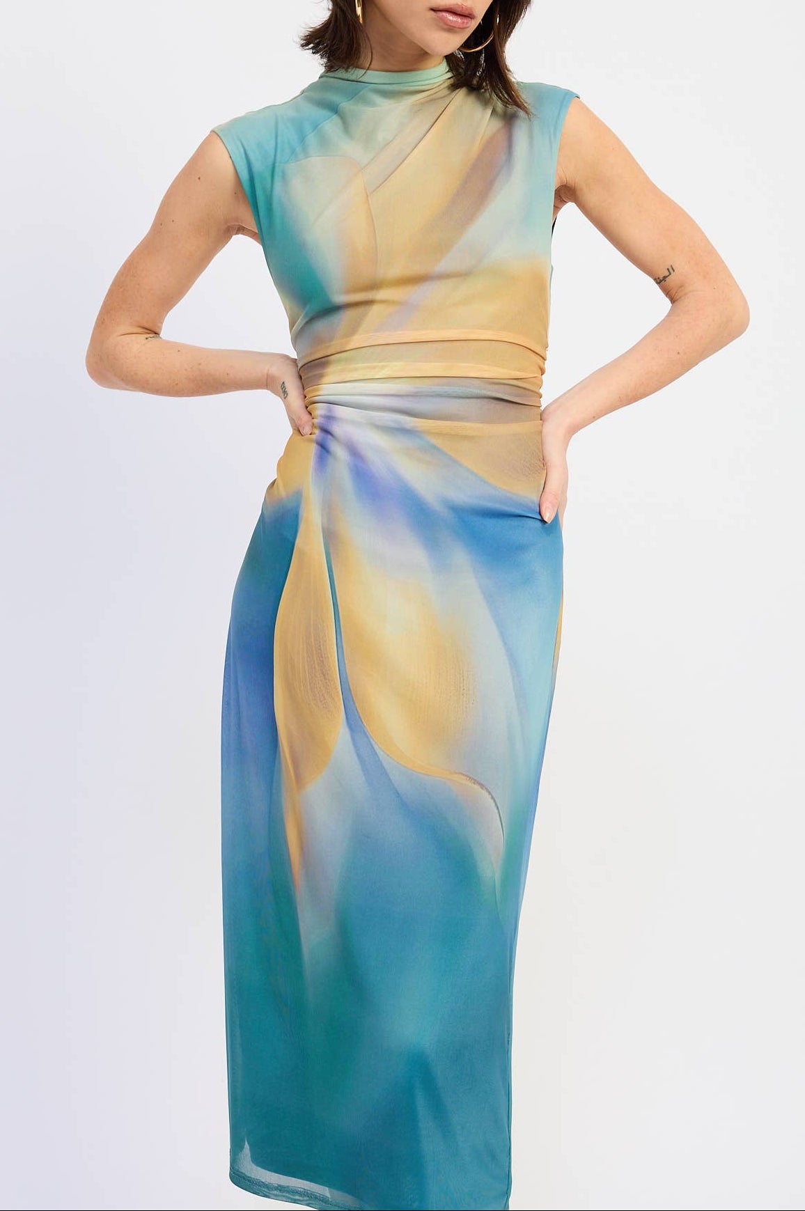 Woman wearing a colorful dress with a gradient design on a light gray background