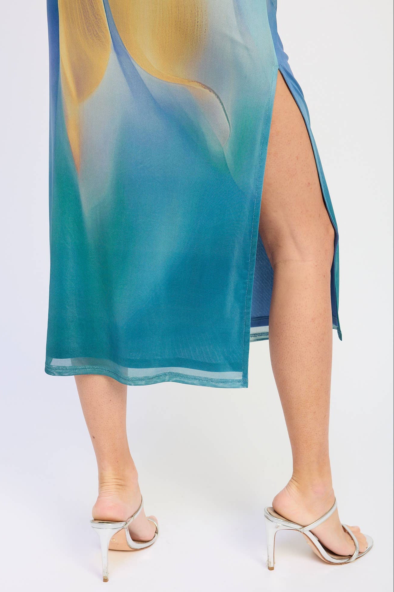 Teal sheer dress with a slit on a white background