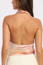 Woman wearing a tie-dye halter top with a white background