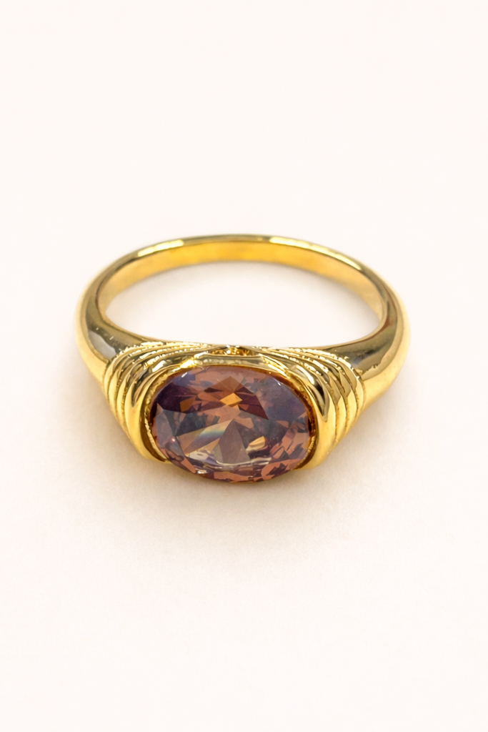 Gold ring with a brown gemstone on a white background