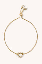 Gold bracelet with heart-shaped clasp on a white background