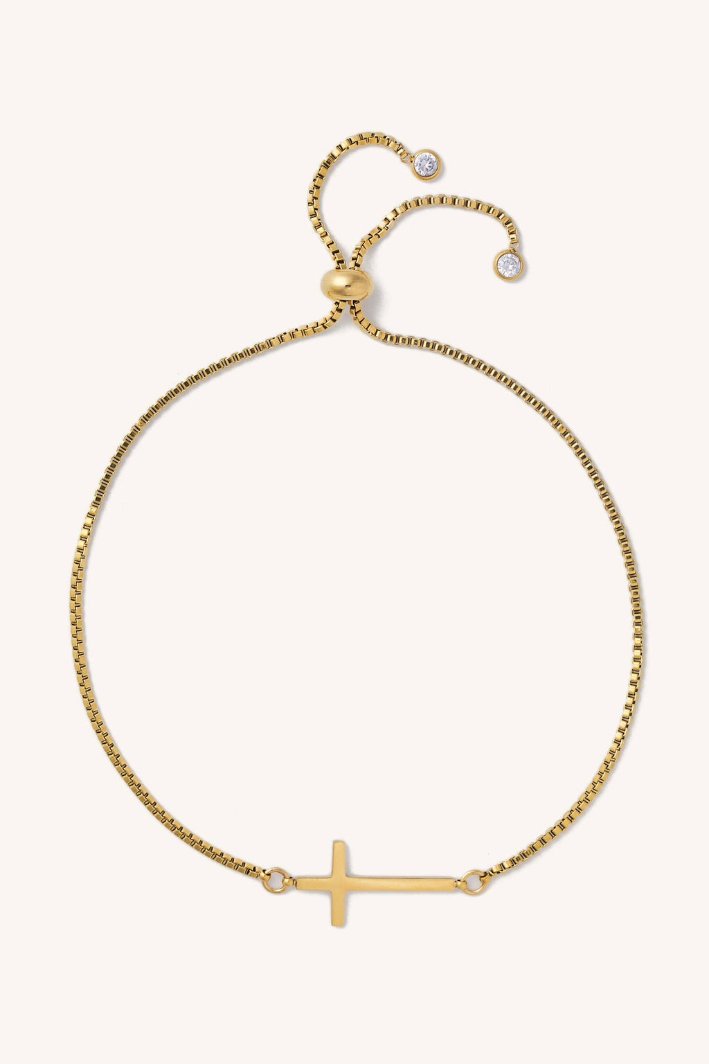 Gold bracelet with a small cross charm on a white background
