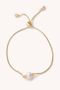 Gold bracelet with a pearl on a white background