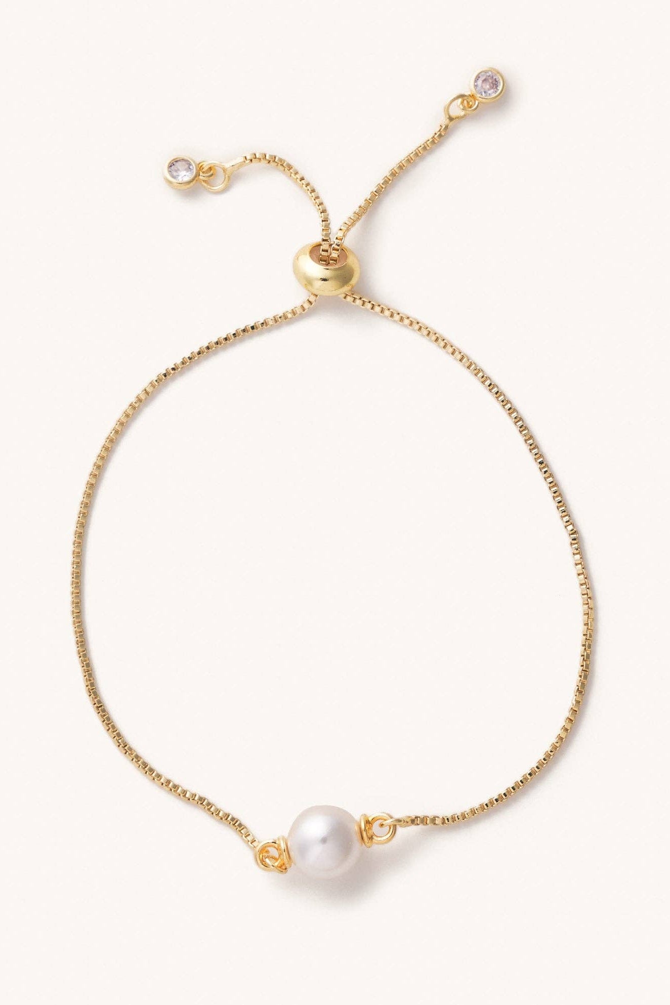 Gold bracelet with a pearl on a white background