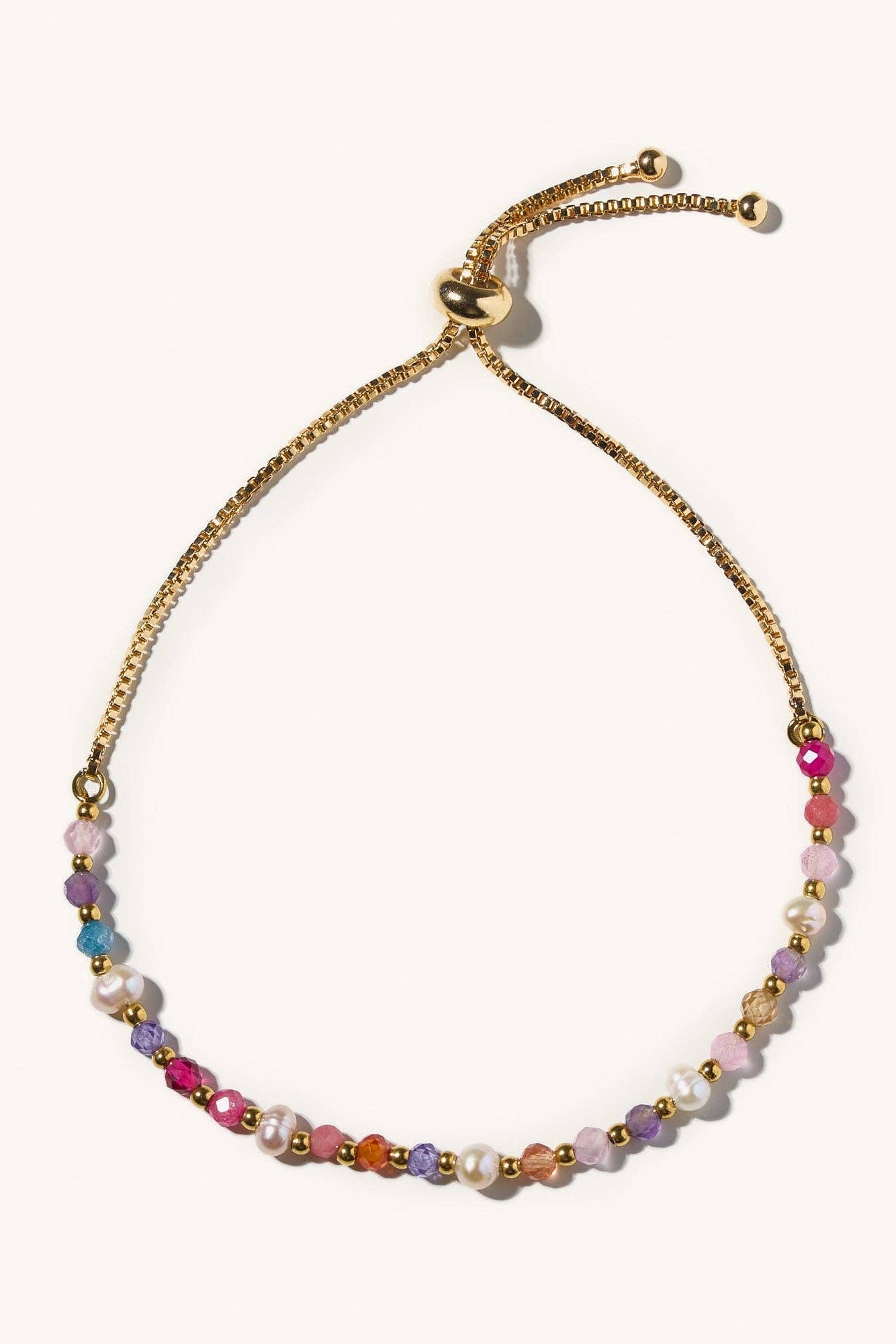 Multicolored beaded bracelet with gold chain on a white background