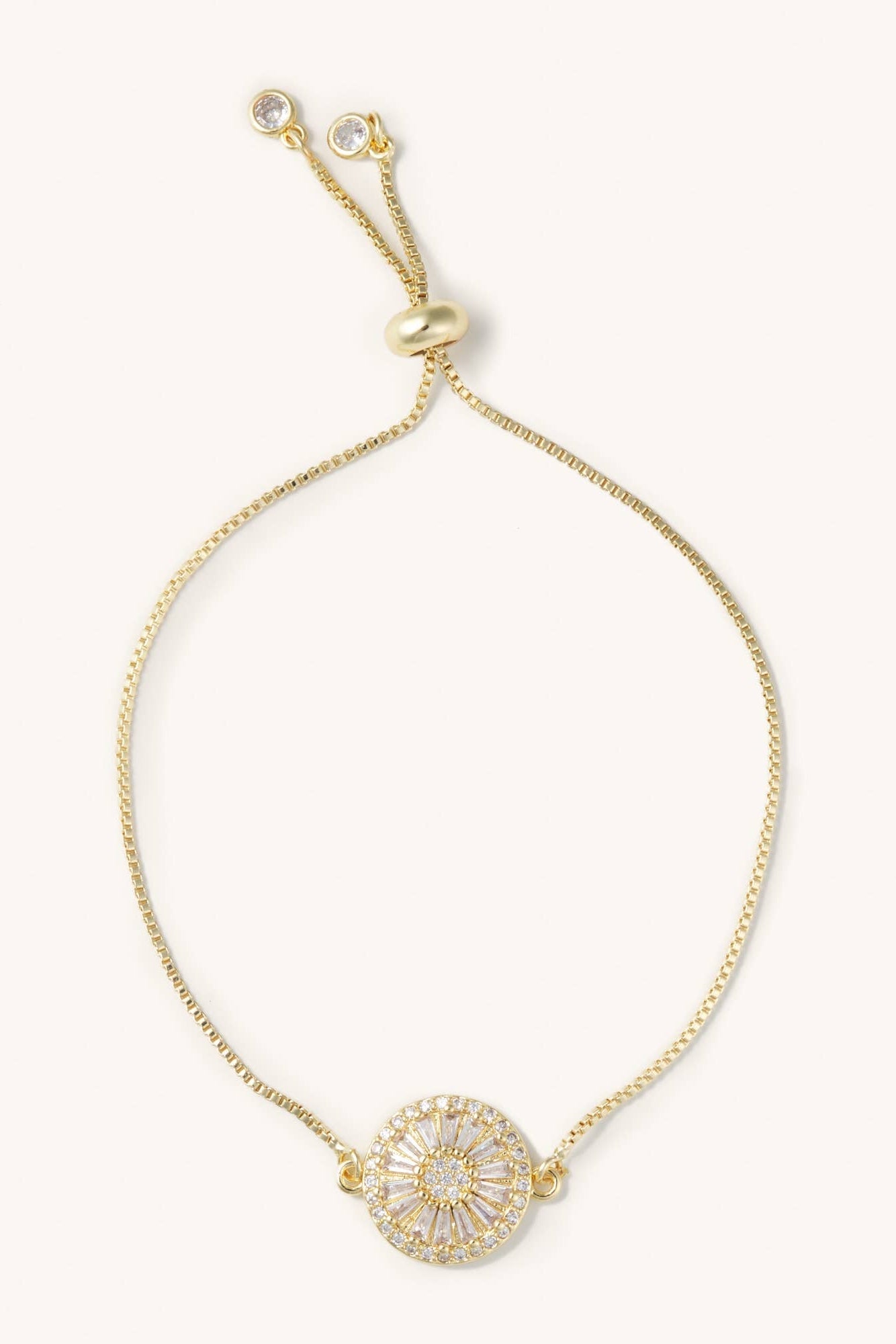 Gold bracelet with a decorative clasp on a white background