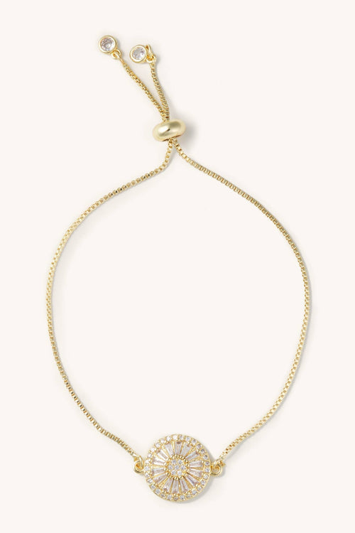 Gold bracelet with a decorative clasp on a white background