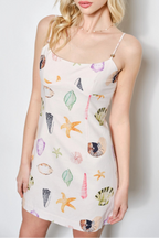 Woman wearing a floral slip dress against a plain background