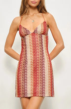 Woman wearing a patterned dress against a plain background