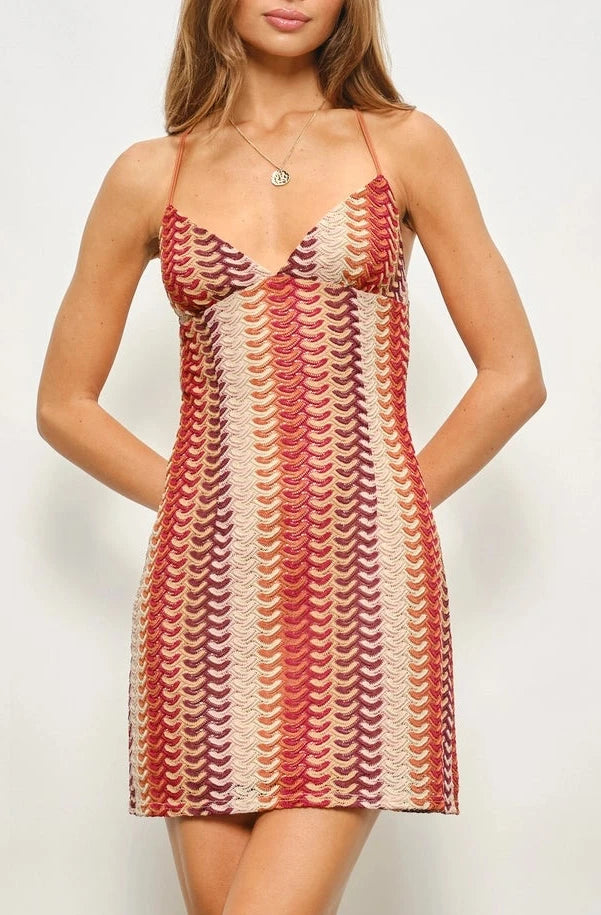 Woman wearing a patterned dress against a plain background