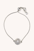 Silver bracelet with a round pendant on a white background