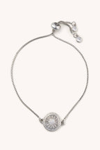 Silver bracelet with a round pendant on a white background