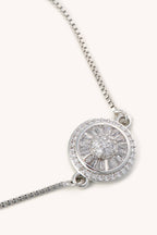 Silver necklace with a round pendant on a white background