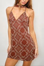 Woman wearing a patterned dress against a plain background