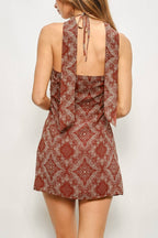 Woman wearing a patterned dress against a plain background