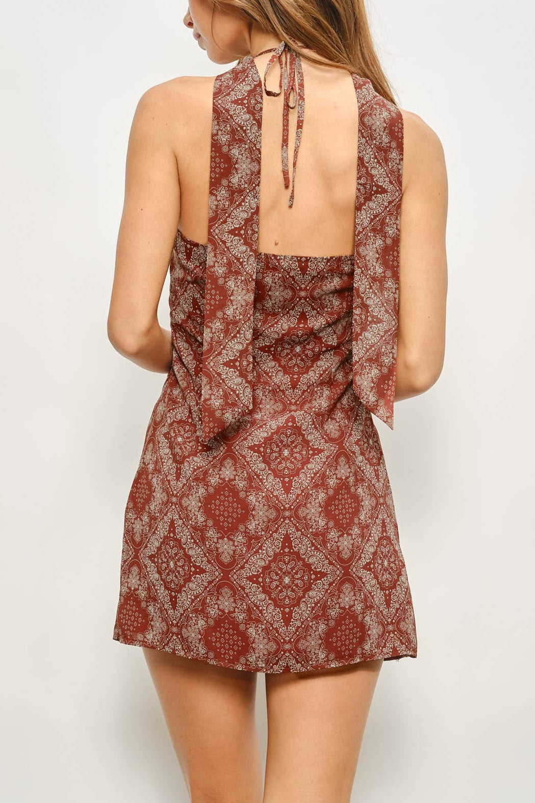 Woman wearing a patterned dress against a plain background