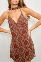 Woman wearing a patterned dress against a plain background