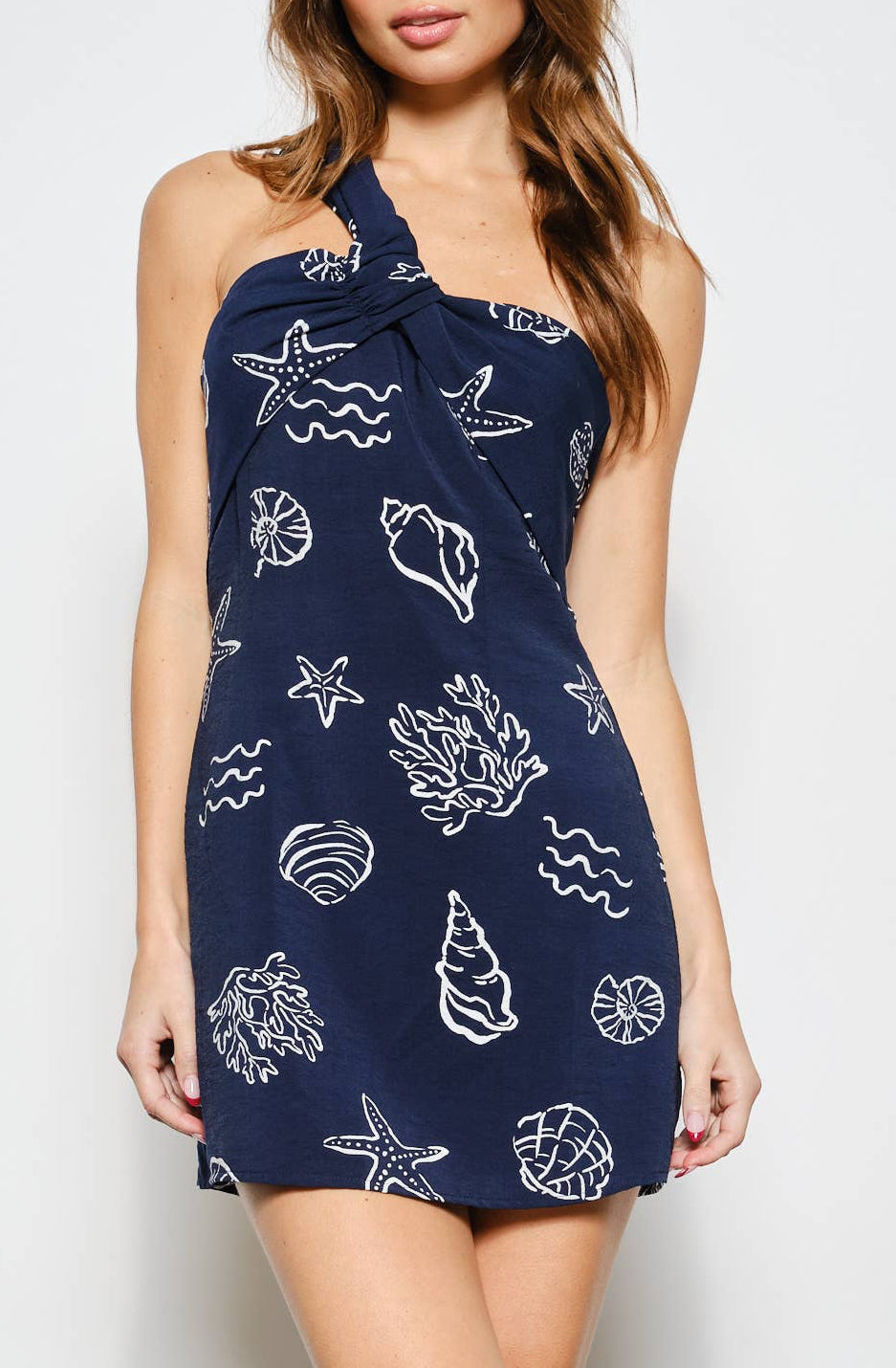 Woman wearing a navy blue dress with white patterns against a white background