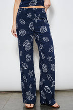 Navy blue pants with white shell pattern worn by a person against a white background