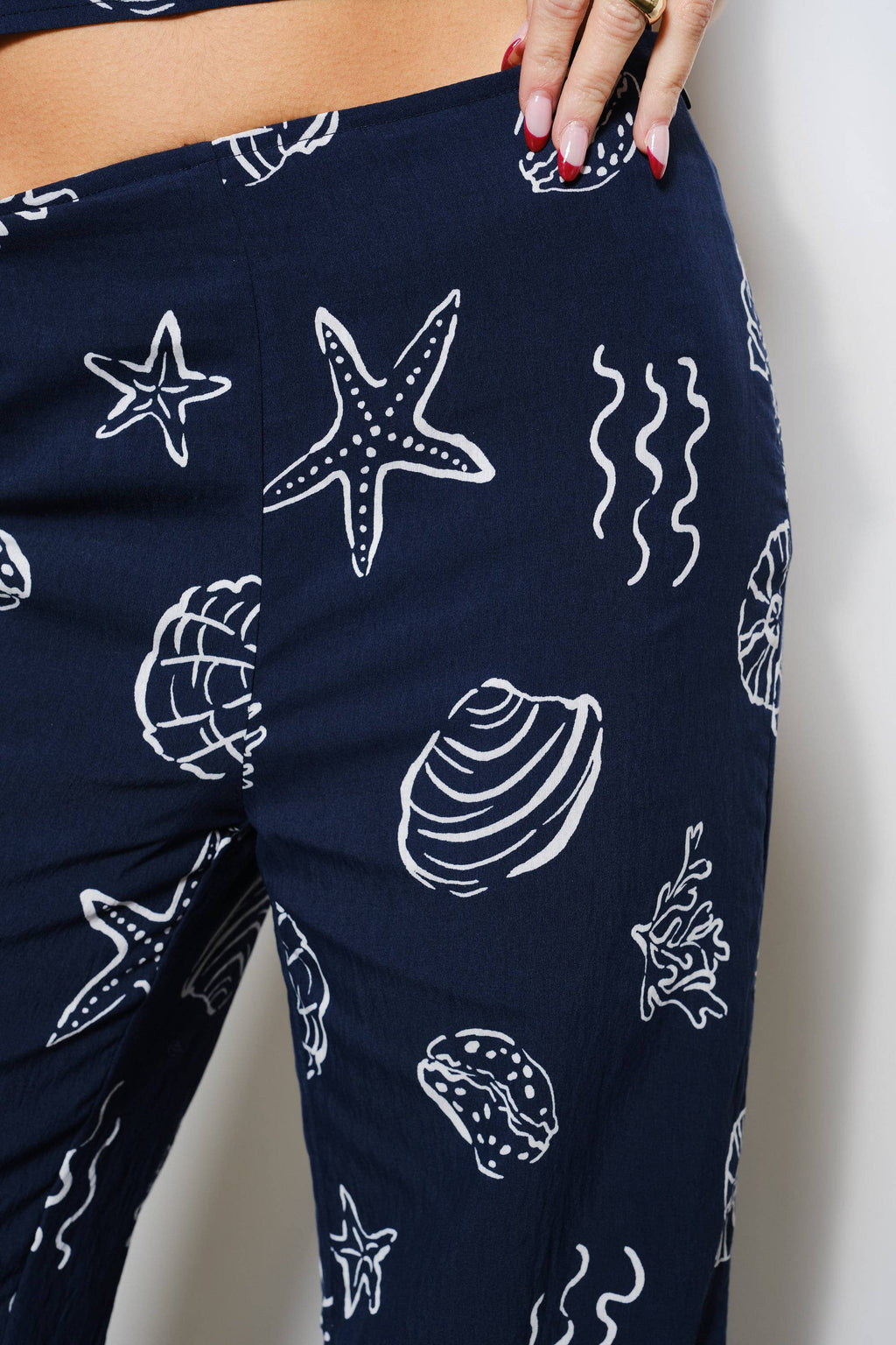 Navy blue leggings with white sea-themed patterns on a plain background