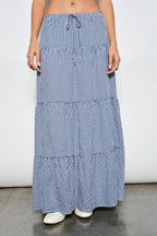 Person wearing a blue and white checkered skirt on a plain background