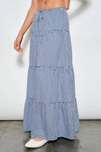 Blue and white checkered skirt worn by a person on a plain background