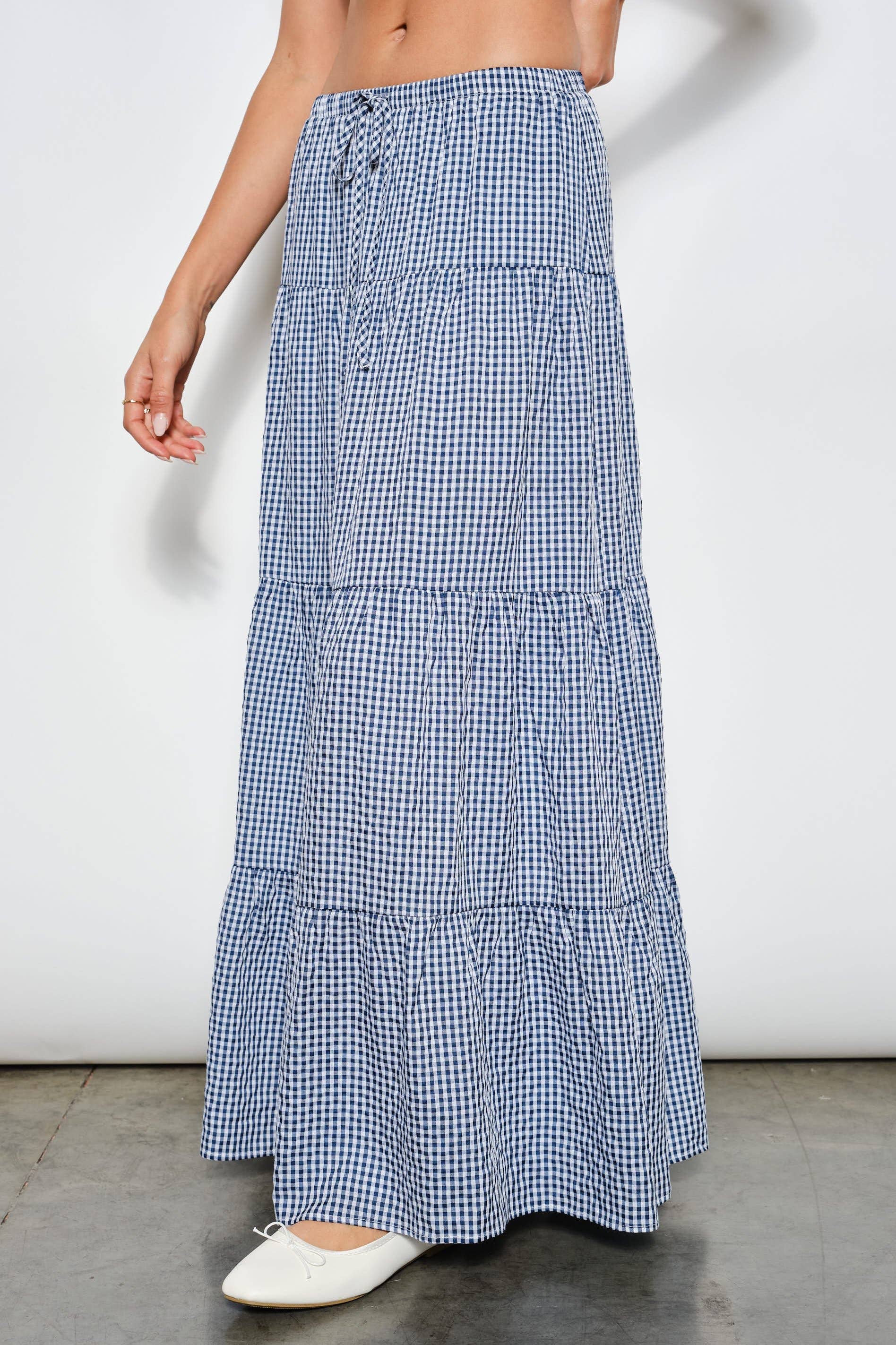 Blue and white checkered skirt worn by a person on a plain background