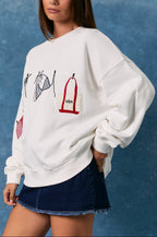 Woman wearing a white sweatshirt with graphic designs against a blue background