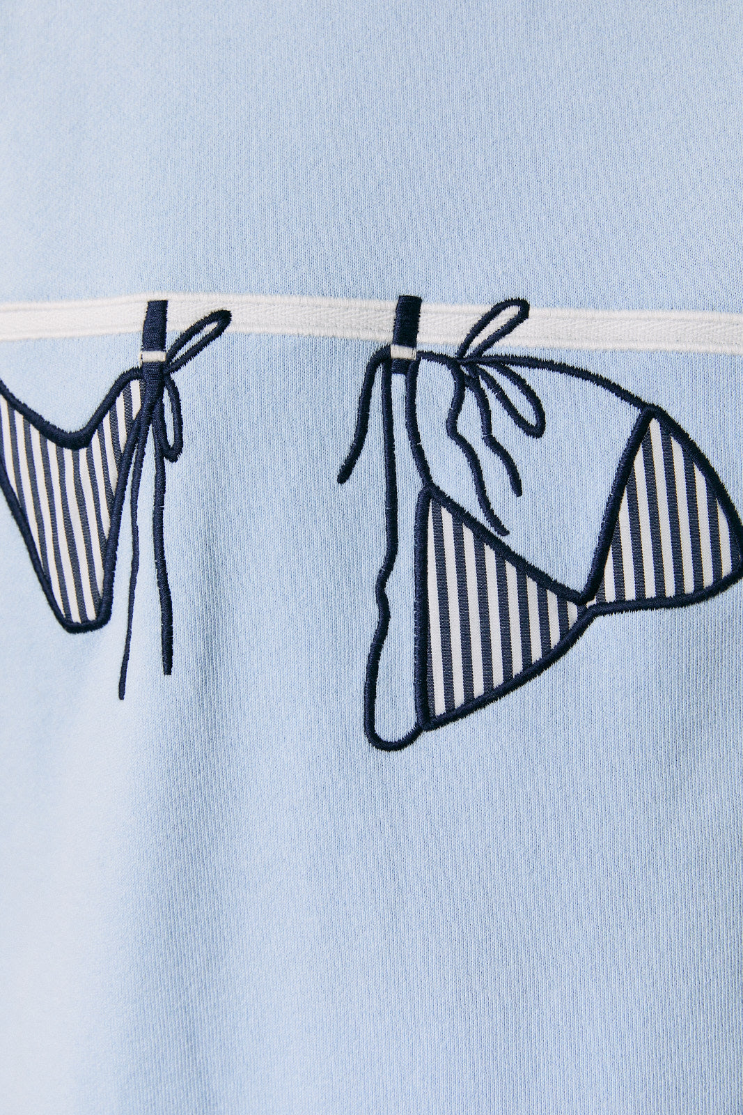 Blue bikini with black stripes on a light blue background