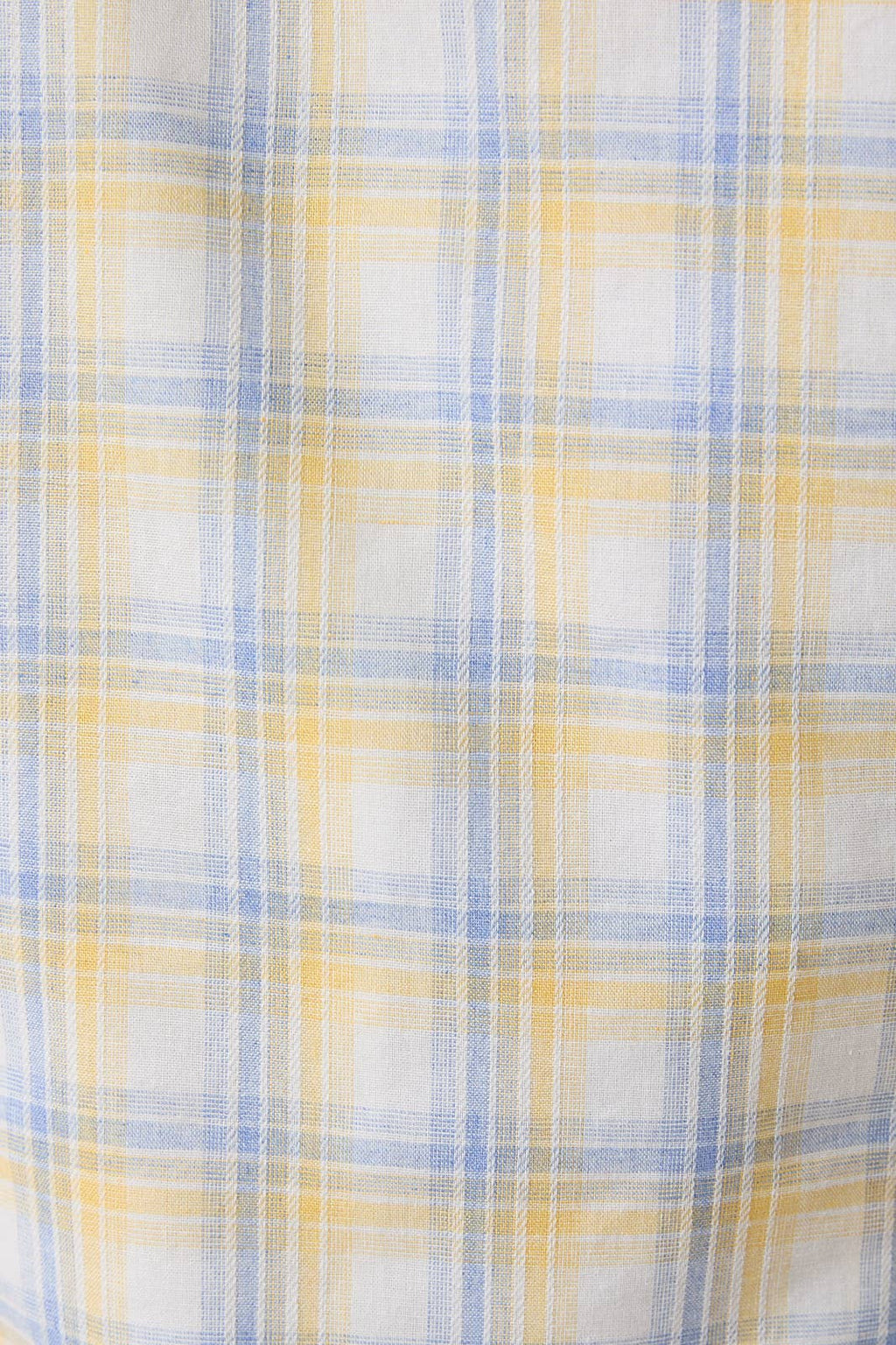 Close-up of a fabric with a yellow, blue, and white checkered pattern.
