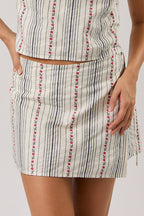 Woman wearing a sleeveless striped skort on a plain background