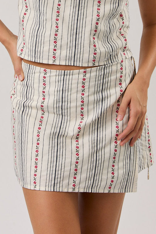 Woman wearing a sleeveless striped skort on a plain background