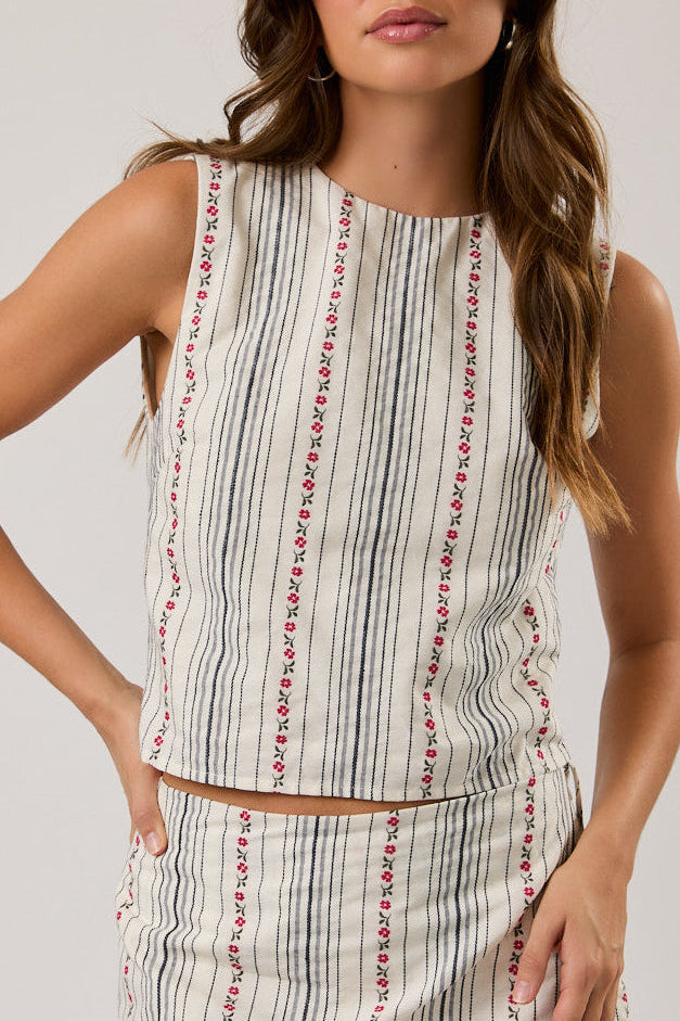 Woman wearing a sleeveless striped top on a plain background