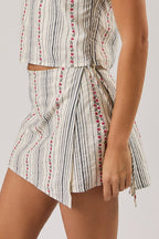 Woman wearing a sleeveless top and skort set with a white background
