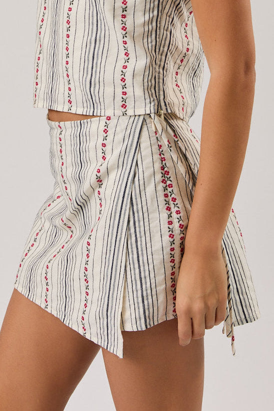 Woman wearing a sleeveless top and skort set with a white background